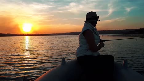 Imágenes-De-Una-Niña-Pescando-En-Un-Lago-En-Un-Bote-Con-Una-Hermosa-Puesta-De-Sol-En-Sudáfrica