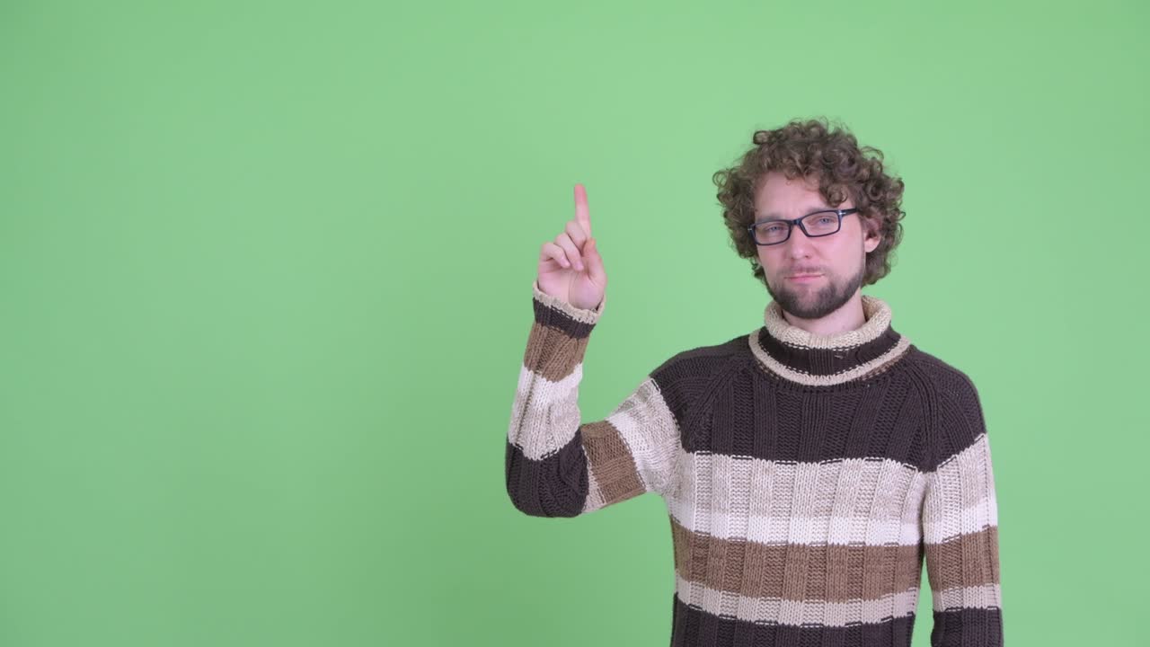 un joven guapo con barba y cabello rizado.