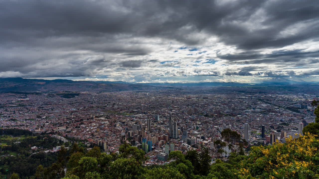 Timelapse z malowniczego punktu widokowego z widokiem na panoramę Bogoty, podczas dramatycznego, pochmurnego dnia. Bogota to rozległa kolumbijska stolica i jedno z największych miast w Ameryce Południowej.