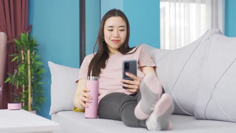 happy asian young woman stretching on the sofa.