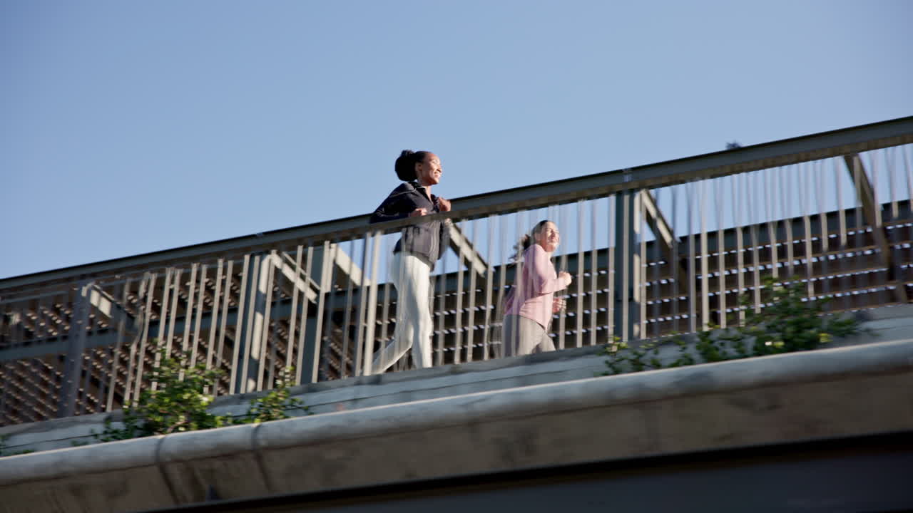 amigas, mujeres corriendo en el puente de la ciudad.