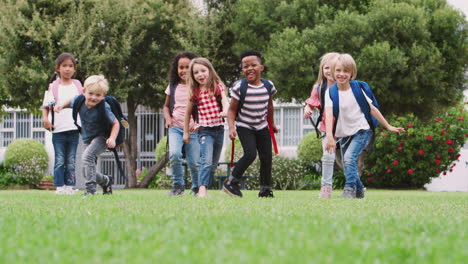 portrait of excited elementary school pupils on playing field at break time