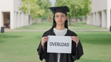 triste chica graduada de la universidad india sosteniendo una pancarta de sobrecarga
