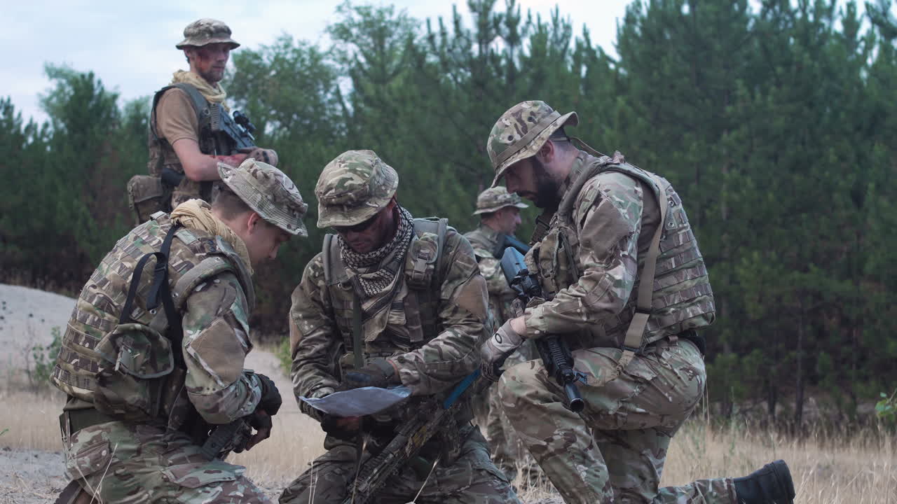 Military Personnel Discussing a Map in the Forest