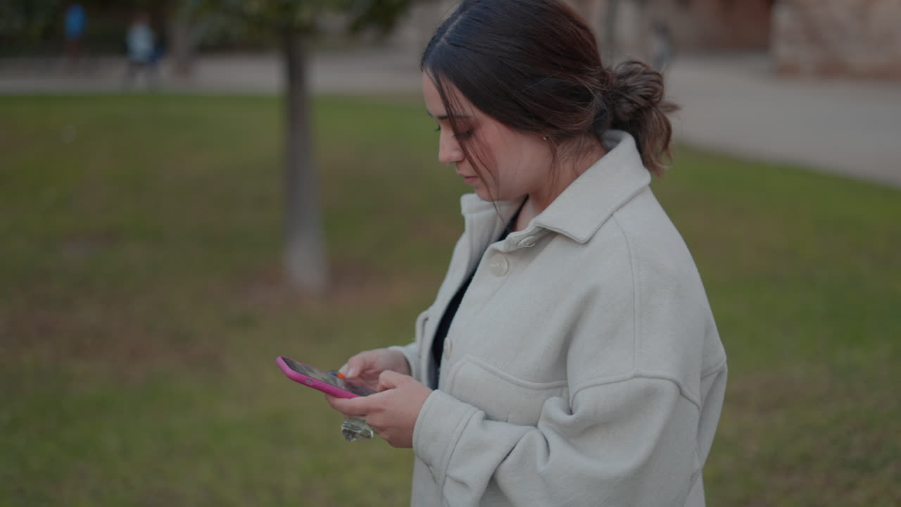 공원에서 스마트폰을 사용하는 여성