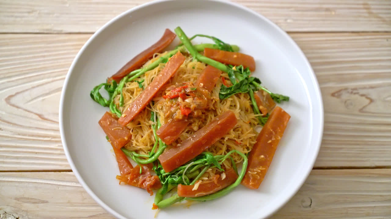 절인 오징어를 곁들인 볶음 쌀 당면과 물 미모사