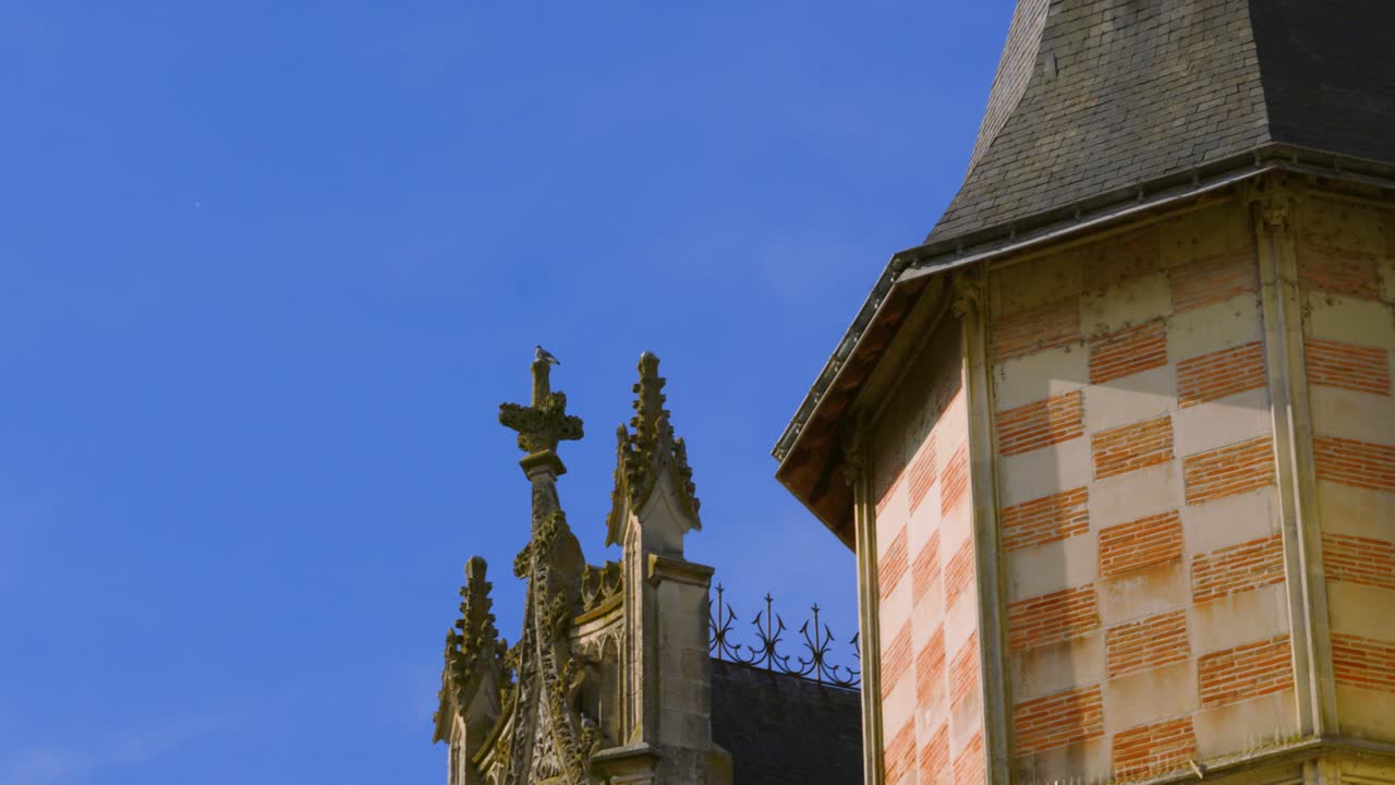 Camera Pan Revealing Roof of Old Historic Château with Christian Cross and Turret in Saumur, France 4K