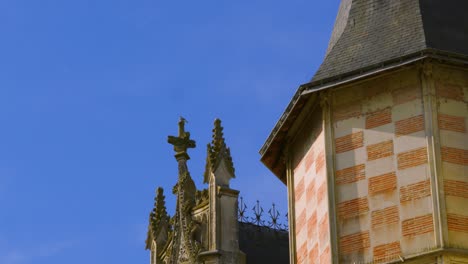 camera pan revealing roof of old historic château with christian cross and turret in saumur, france 4k