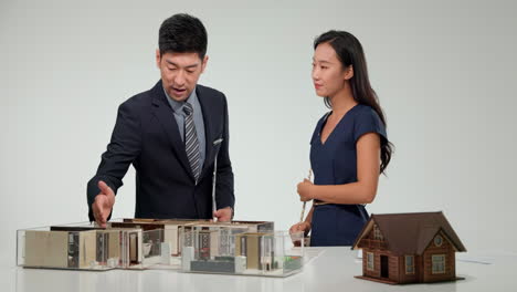 real estate professional architects and financial experts gathering around a table to discuss and plan a new real estate development project strategy doing paperwork in office