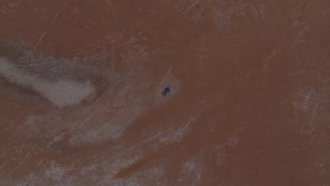 clip de drone de ojo de pájaro del desierto australiano remoto, con modelo masculino tendido en el suelo supino