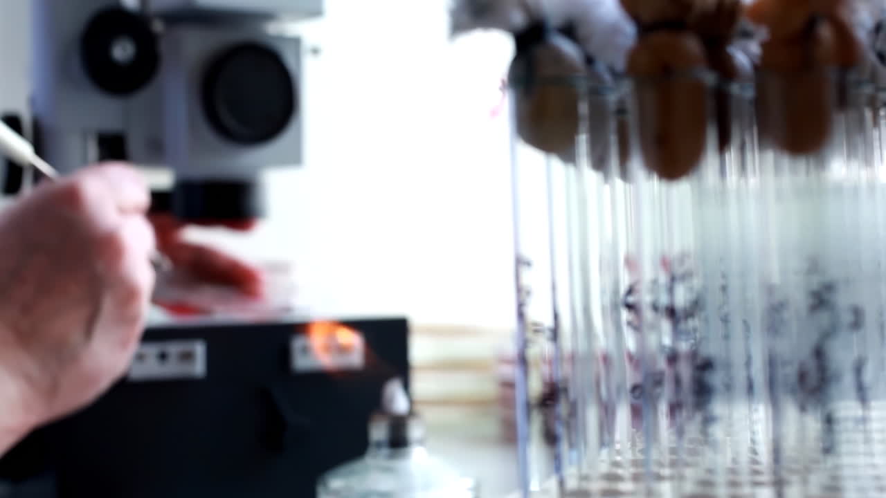 Medicine and research concept. Lab technician in a white coat uses specialized equipment to handle test tubes, showcasing a scientific process in a modern laboratory setting