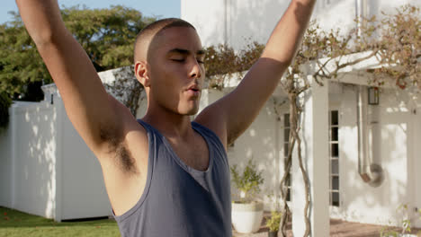 Focused-biracial-man-practicing-yoga-in-sunny-garden,-slow-motion