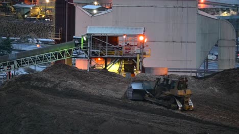 A-Bulldozer-at-Work:-A-Nighttime-View-of-Sawdust-Piling-Up-at-a-Sawmill