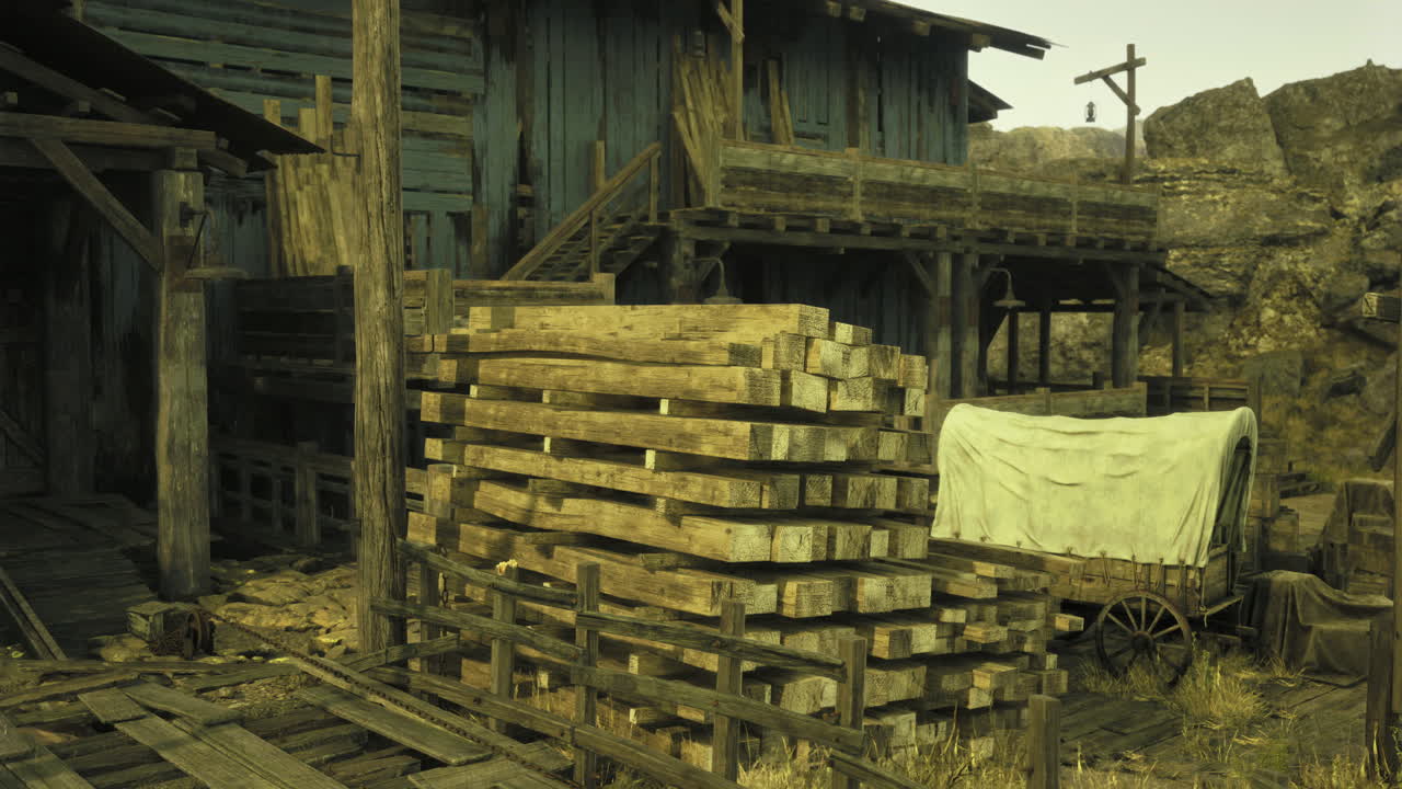 Historic wooden structure and stacks of lumber near a wagon in a desert town
