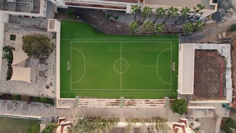 Toma-Aérea-Ascendente-De-Un-Campo-De-Fútbol-Bordeado-Junto-A-Casas-Residenciales