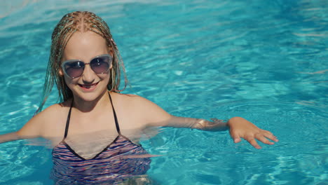 portrait of a child in the pool, looking into the camera, smiling