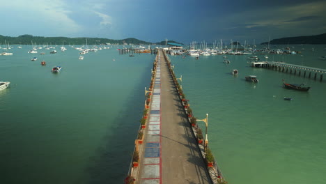 long pier with boats and marina in a tropical location