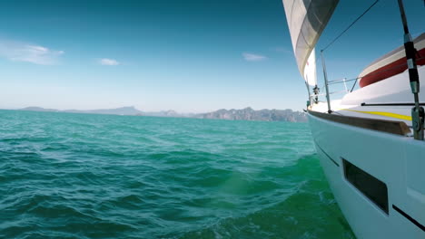 single hull sailing yacht leisurely cruising the green waters of the adaman sea, thailand