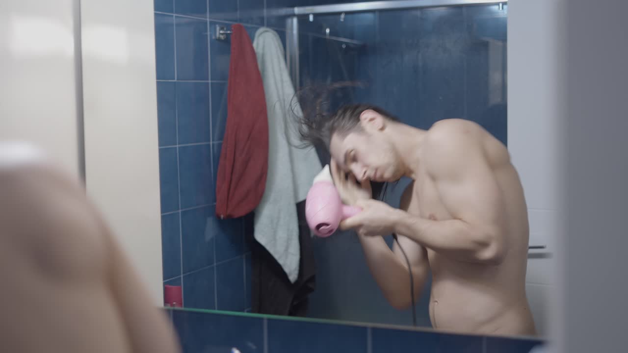 욕실 에서 머리카락 을 건조 시키는 남자