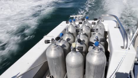 scuba diving tanks secured on a dive boat travelling to the great barrier reef