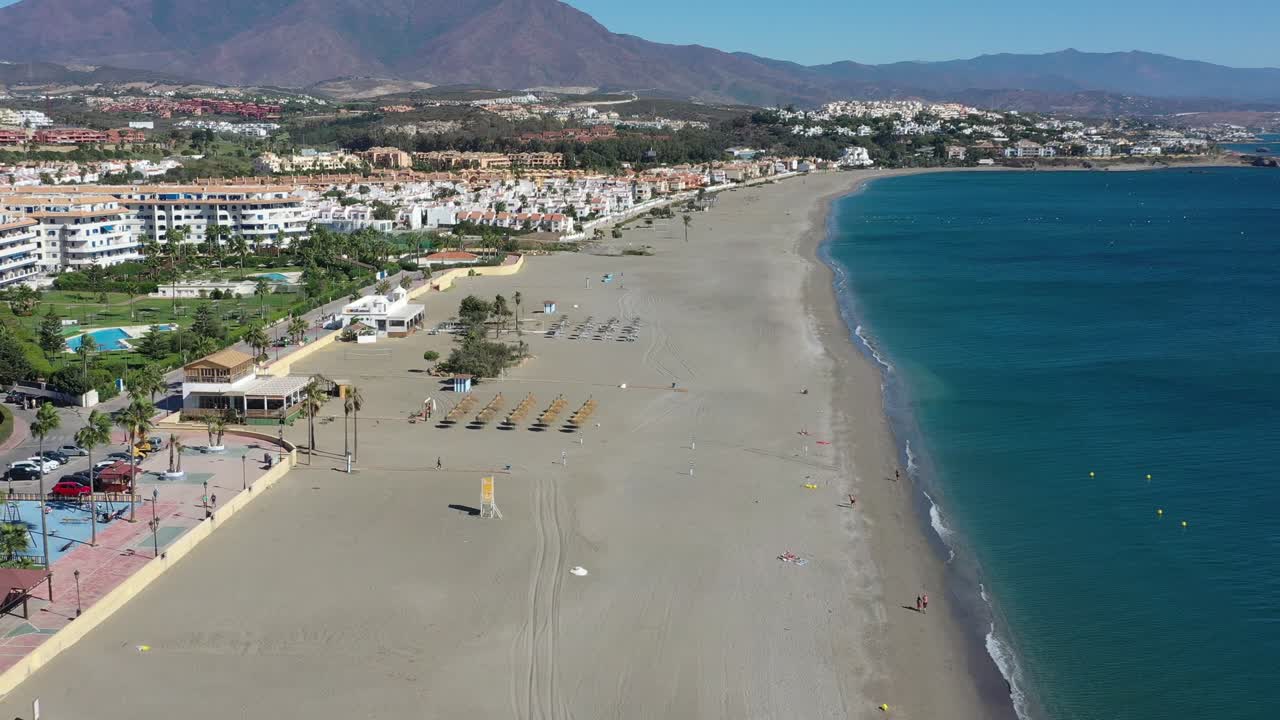 Vista aerea di una spiaggia sabbiosa con ombrelloni di paglia. Spagna