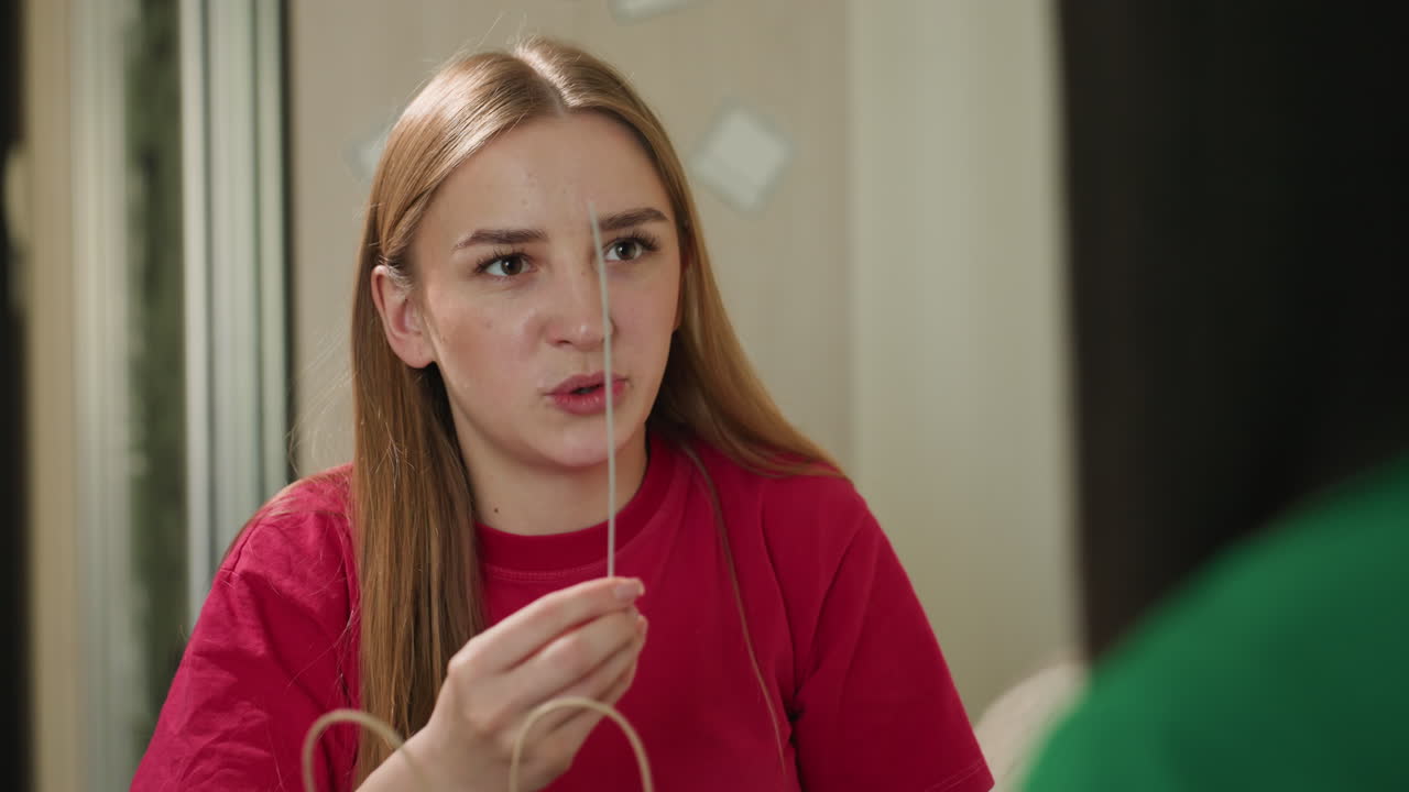 Una mujer examina alegremente accesorios en un interior; una mujer rubia examina felizmente accesorios de joyería; una mujer rubia alegre inspecciona pensativamente su collar mientras sonríe en un interior.