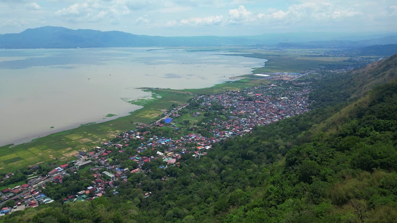 Rekaman udara drone kota Pakil di Laguna, Filipina, dengan tanaman hijau tropis, pemandangan pegunungan, jalan pedesaan, dan lanskap pedesaan Filipina tradisional