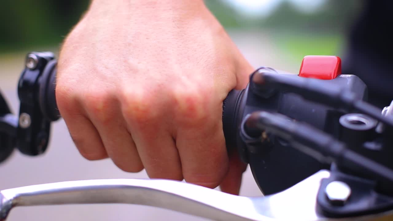 Motorcycle rider starting engine and revving throttle on bike on open road