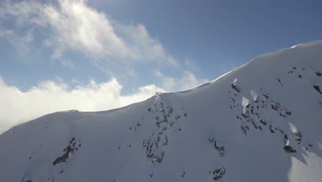 snowy mountain peaks with clouds