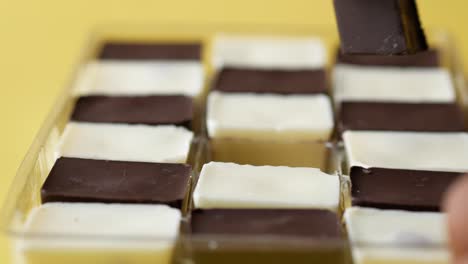 hand picking chocolates from a box