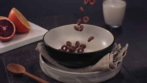 super slow motion healthy breakfast, chocolate cereal falling into a bowl on a table. shot with high speed camera at 420 fps