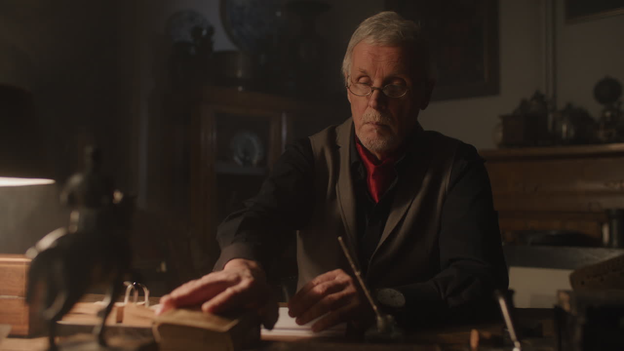 Old passionate man read a book in his office at night