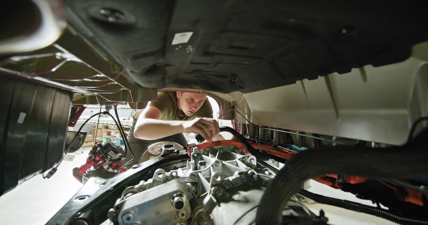 Mechanic repairing an electric car engine in a modern workshop concept of ev maintenance service and