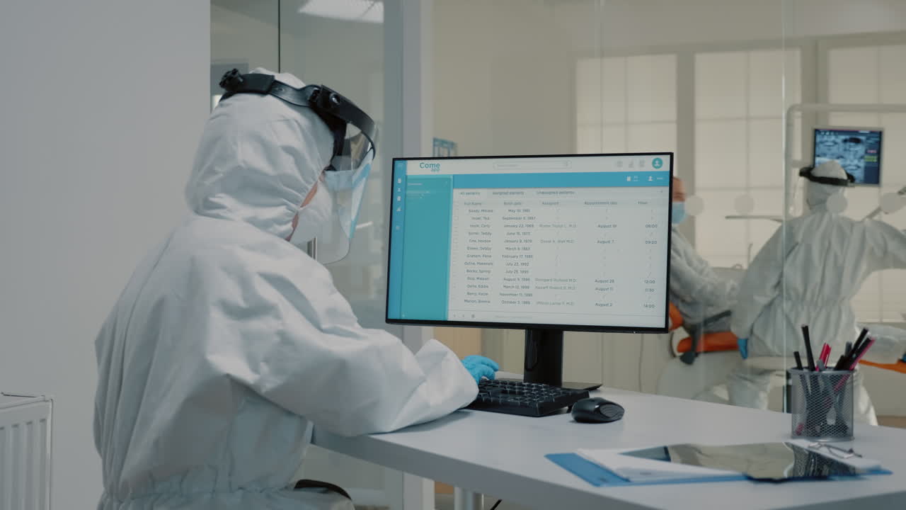 asistente odontológico que trabaja en computadora en una clínica odontológica