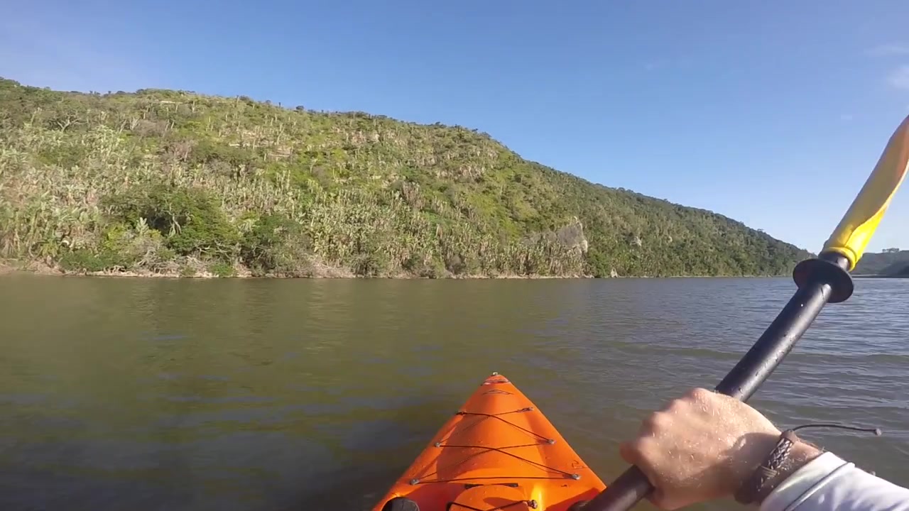 POV-beelden van kajakken bij de Oost-Kaap, Zuid-Afrika. Draait zich om naar een vishengel in de achtersteven van de boot. Prachtige natuurlijke omgeving