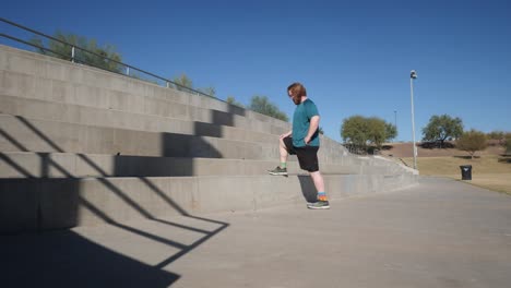 Red haired man stretching on Cement blocks.