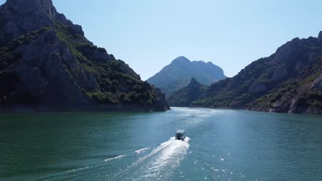 4K-Drohnenclip,-Der-Einem-Flussboot-Im-Riaño-See-In-Kastilien-Und-León-In-Spanien-Folgt