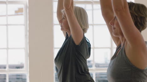 Yoga-Klasse-Schöne-Alte-Frau-Praktiziert-Krieger-Pose-Meditation-Und-Genießt-Das-Körperliche-Fitnesstraining-In-Der-Gruppe-Im-Studio