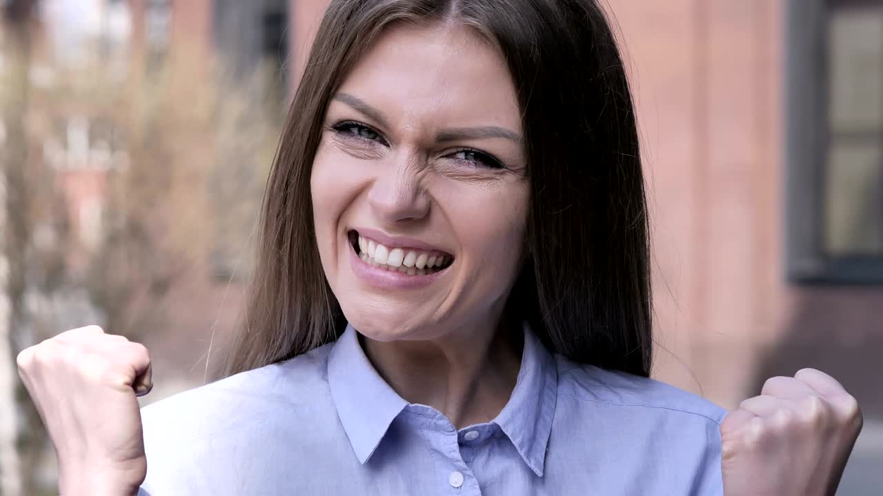 mujer emocionada reaccionando al éxito, estando fuera de la oficina