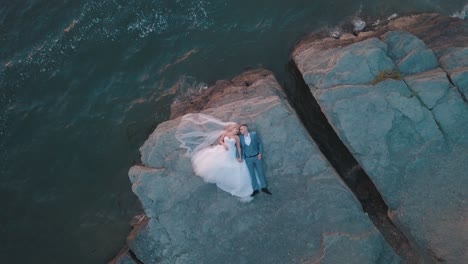 wedding newlyweds couple are lying on a mountainside by the sea. aerial shot