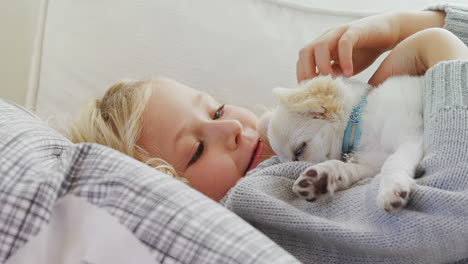 niña acostada en el sofá acariciando a su mascota en casa 4k 4k