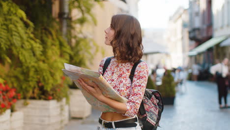 woman lost while traveling in europe city exploring sightseeing navigating holds tourist paper map