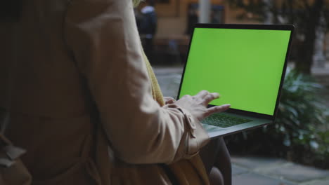 mujer joven escribiendo en la computadora portátil