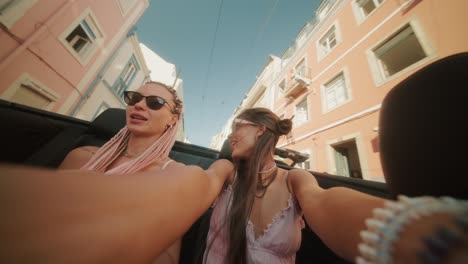 two women enjoying a convertible ride through the city