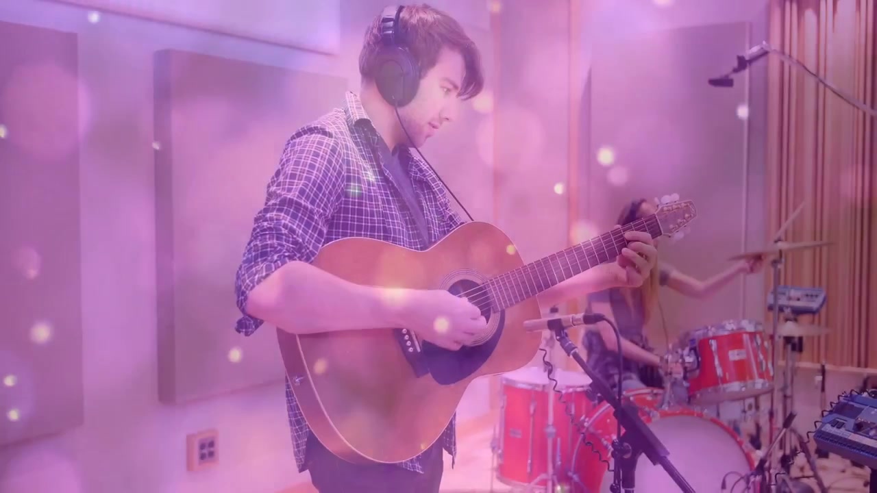 Vídeo vertical: Guitarrista dedilhando e baterista marcando o ritmo, gravação começando, com efeito bokeh rosa.