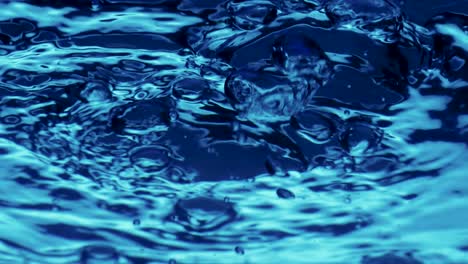 bubbling water surface with air bubbles rising up bubbling water surface with air bubbles rising up blue transparent liquid vibrates creating splashes and ripples on the surface boiling water bubbling transparent blue aqua close up