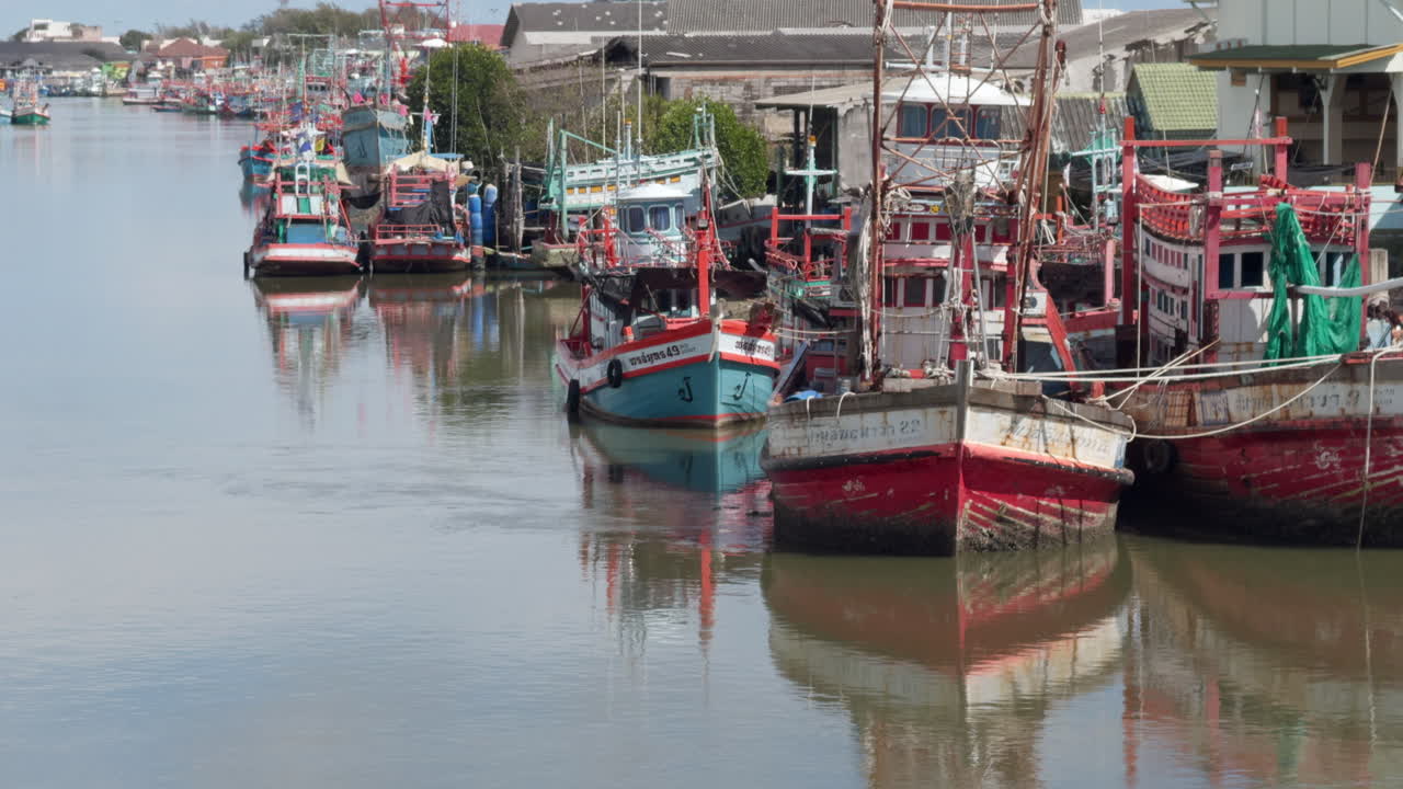 Fischerboote liegen im Hafen von Rayong, Thailand, vor Anker, mit ruhigen Wasserreflexionen. Traditioneller Fischereihafen mit farbenfrohen Schiffen, maritimer Industrie und Küstenleben in Südostasien.