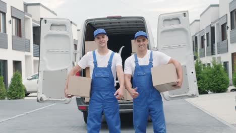 two young workers of removal company deliver boxes to a customer's home