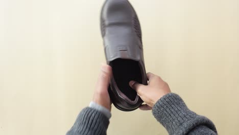 hombre con un par de zapatos de cuero marrón