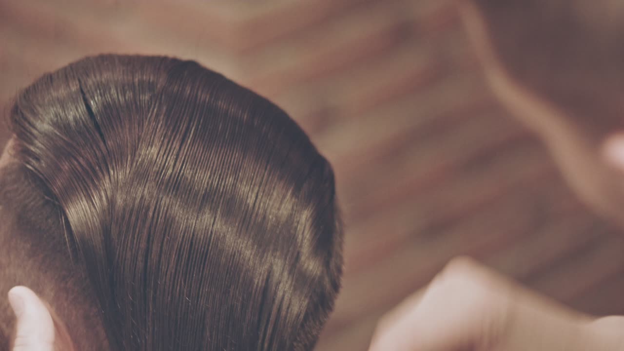 Barber comb male hair in salon. Male hair stylist. Man combing hair